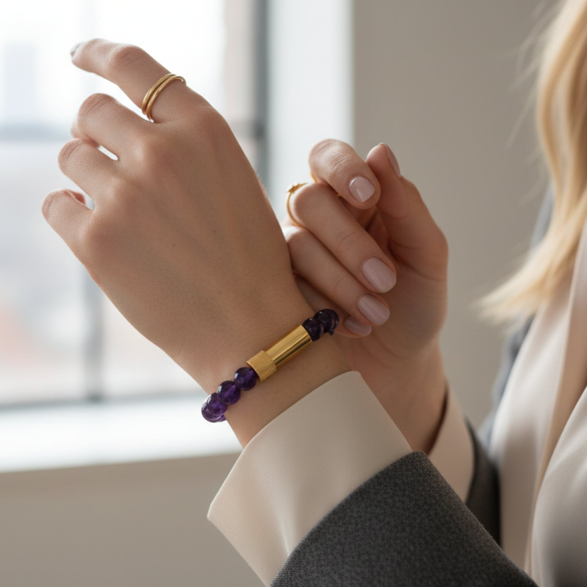 Purple beaded bracelet with gold accents on a white background
