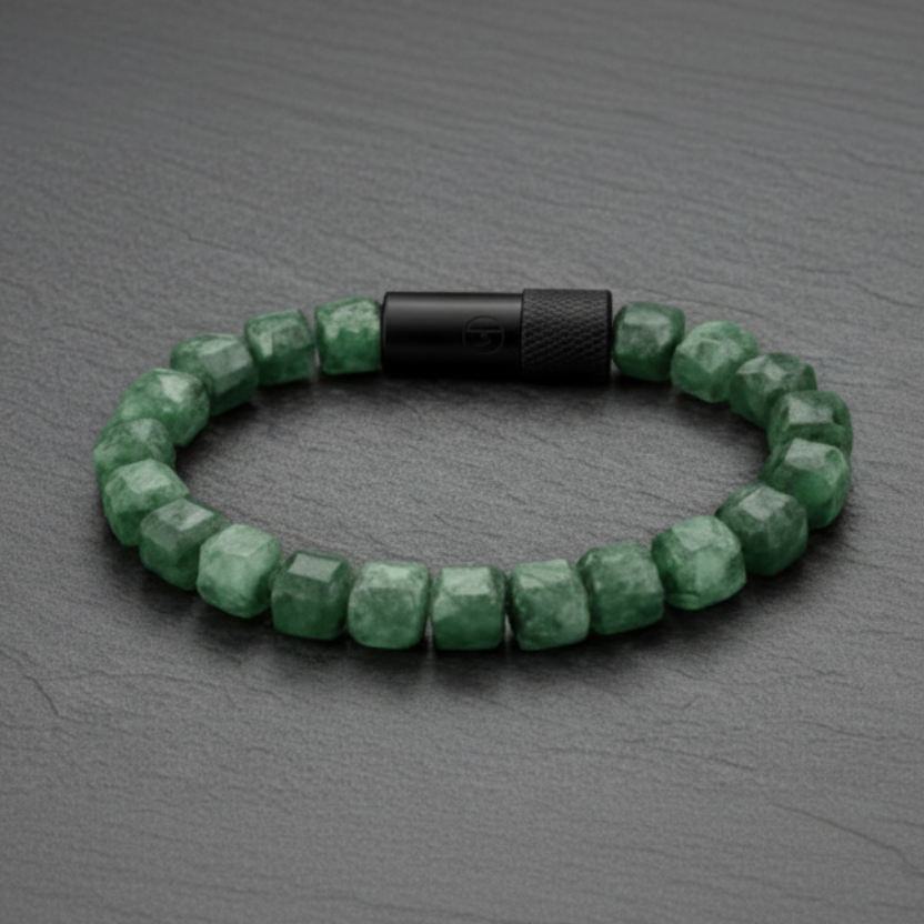 Green beaded bracelet with a black clasp on a dark surface