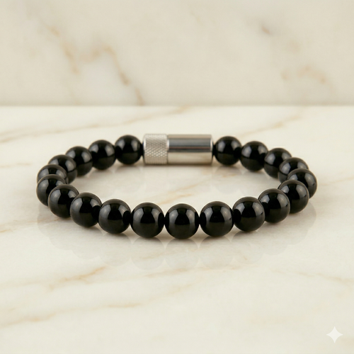 Black beaded bracelet with a silver clasp on a marble surface