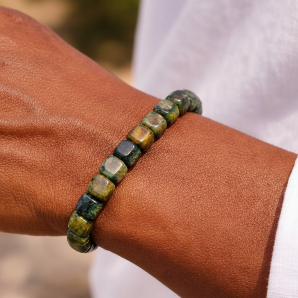 Green beaded bracelet on a wrist with a blurred background