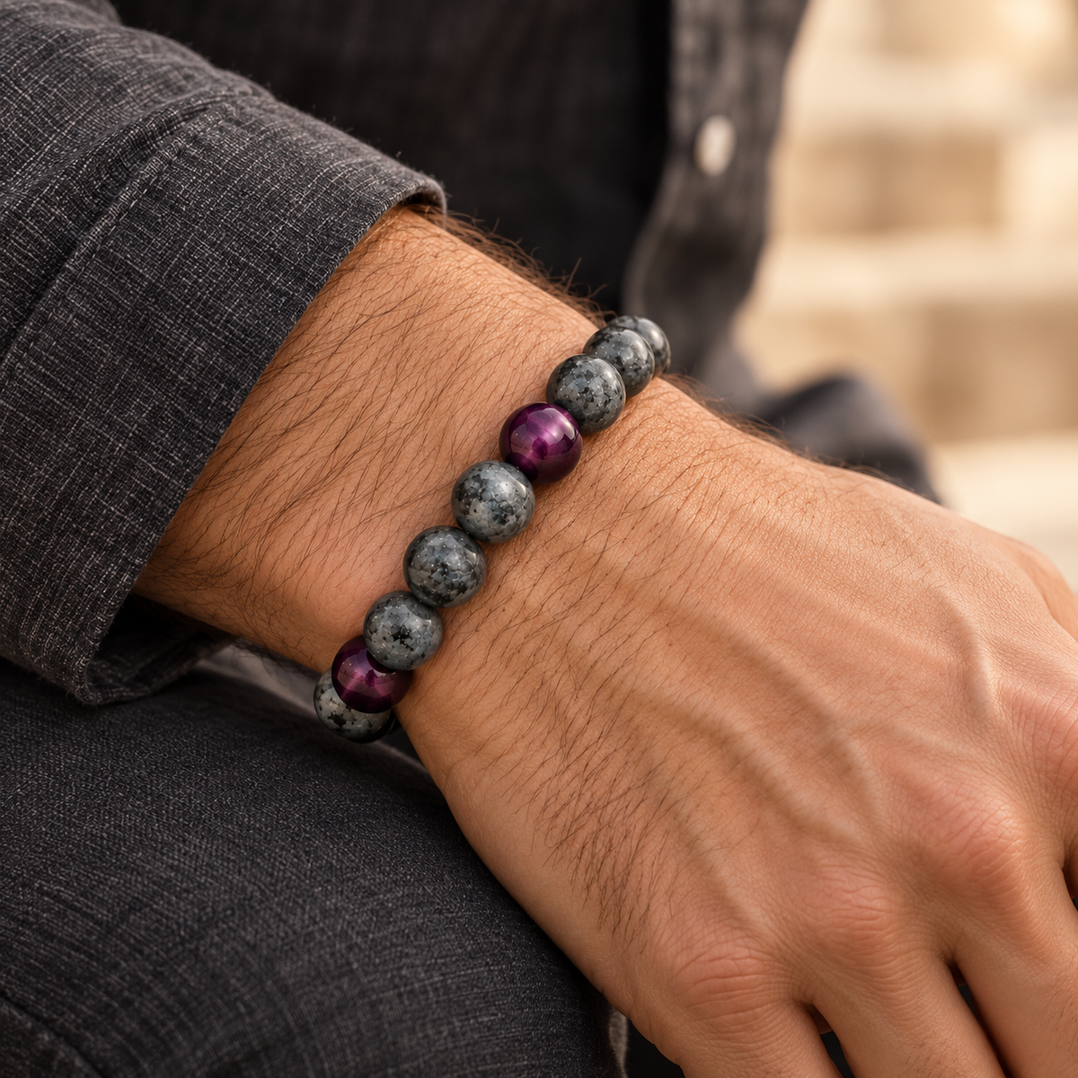 on a mans wrist wearing black jeans Matte gray Labradorite and purple Tiger’s Eye Embracelet™ with a discreet silver pill holder, displayed 