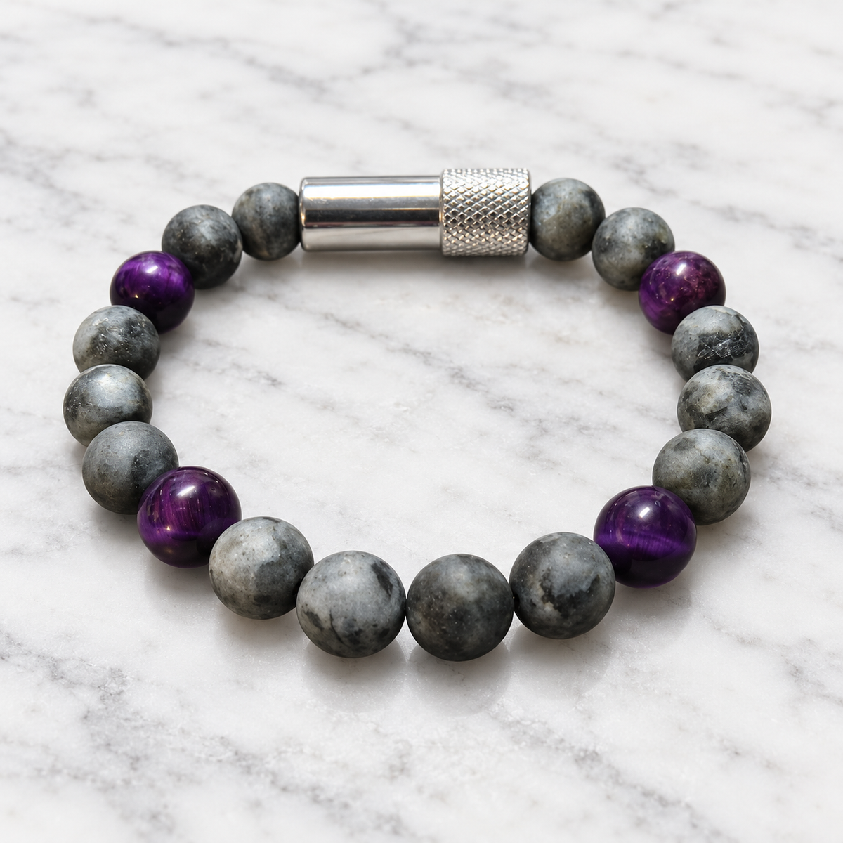 Matte gray Labradorite and purple Tiger’s Eye Embracelet™ with a discreet silver pill holder, displayed on white marble.
