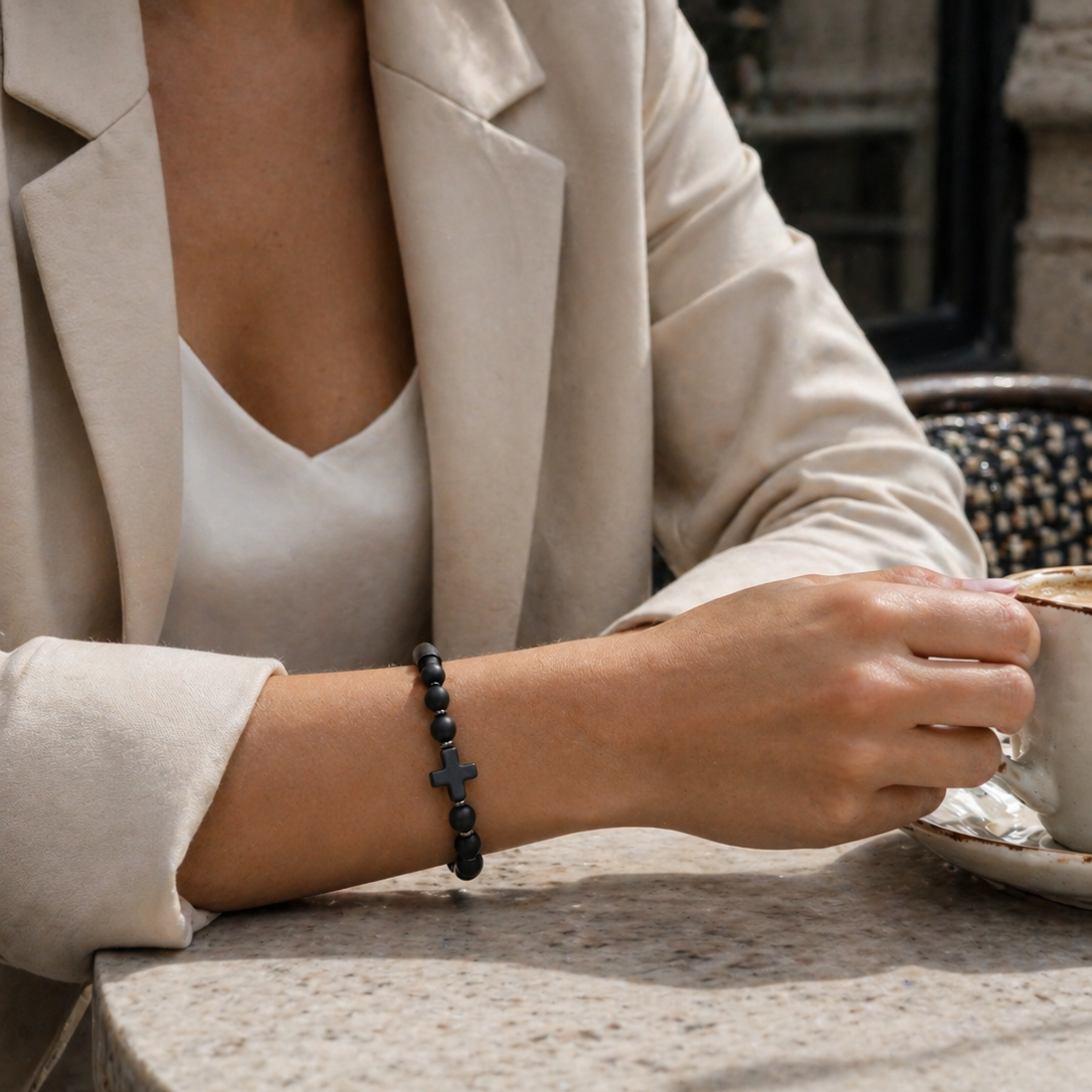 Person wearing a beige blazer and white top, holding a cup with a blurred background