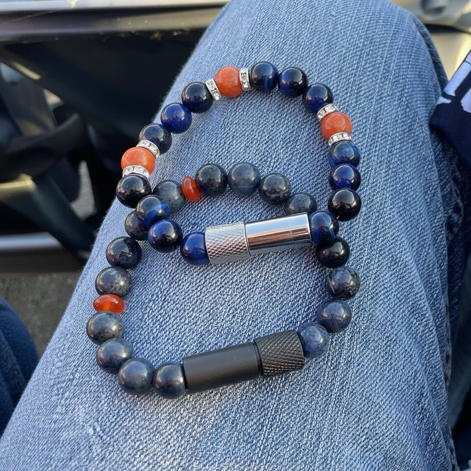 Bracelet with blue, orange, and silver beads on a person's lap.